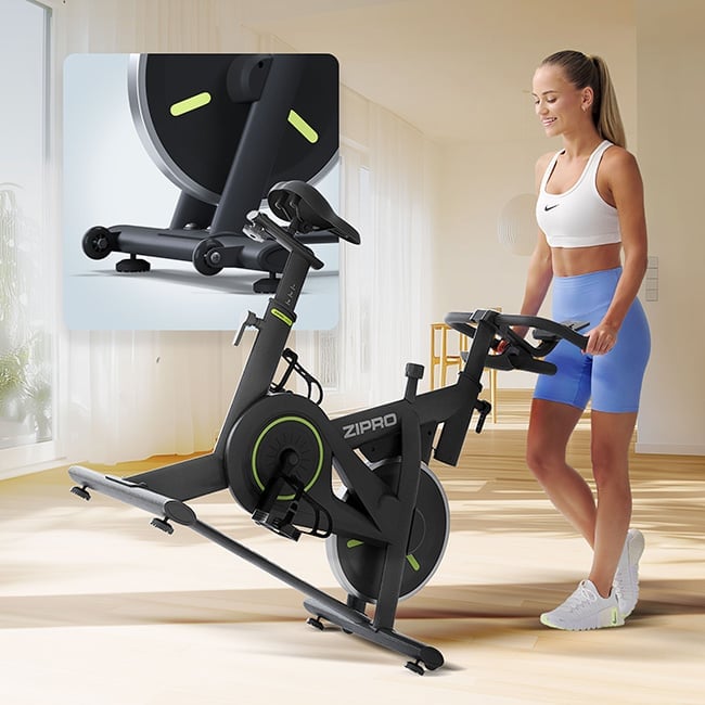 Rower spinningowy ZIPRO Modo - Kobieta przestawia rowerek po skończonym treningu, dzięki wbudowanym kółkom transportowym.
