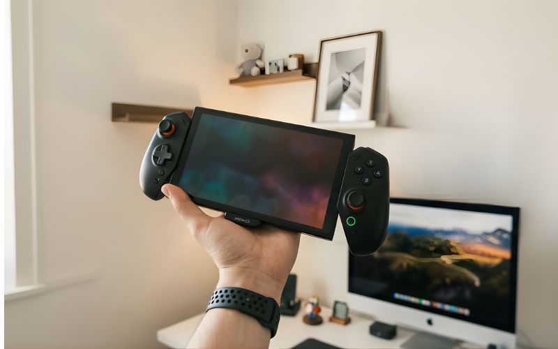 Kontroler YAXO Evo Deck do Nintendo Switch 2 trzymany w dłoni na tle stanowiska komputerowego