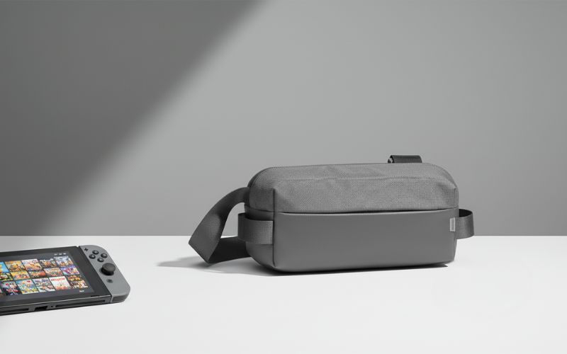 Szara torba YAXO na konsolę ustawiona na jasnym tle, po lewej widoczny fragment Nintendo Switcha.
