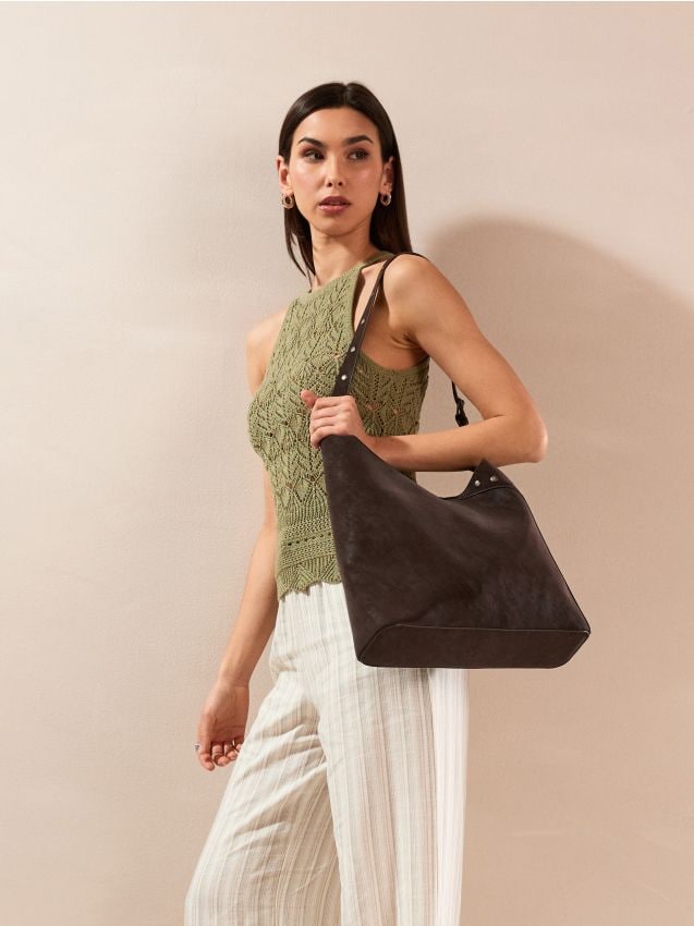 Hobo-Tasche aus Kunstleder mit dekorativen Nieten und Kosmetiktasche